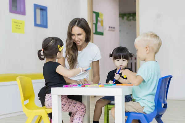 Leraar met leerlingen op tafel — Stockfoto