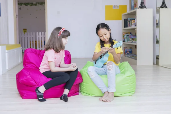 Zwei kleine Mädchen spielen im Kindergarten Gitarre — Stockfoto