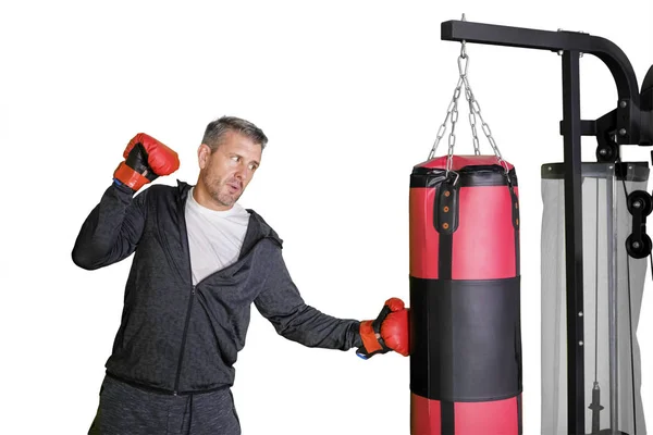 Young man hitting on a boxing bag in the studio — Stock Photo, Image