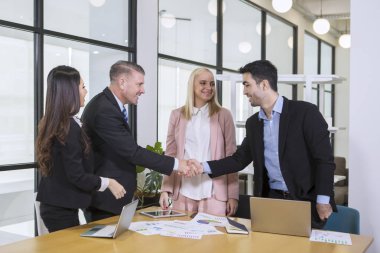 Diversity team in business. Businessman shaking hands clipart
