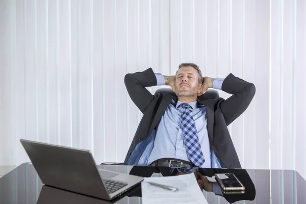 Kaukasischer Geschäftsmann entspannt sich an seinem Schreibtisch im Büro — Stockfoto