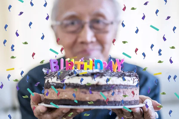Dziadek trzyma tort urodzinowy — Zdjęcie stockowe