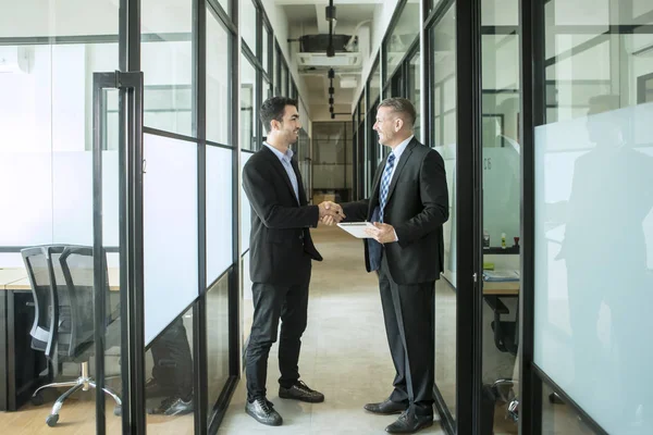 Empresários felizes apertando as mãos no escritório — Fotografia de Stock