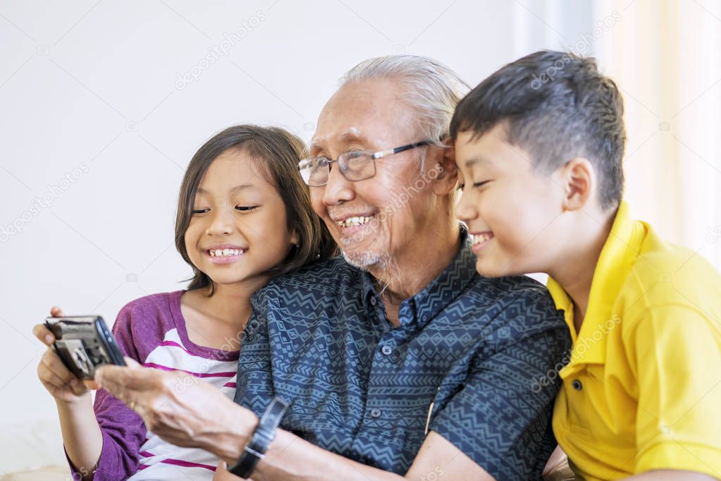 grandfather and grandchildren watching a movie together