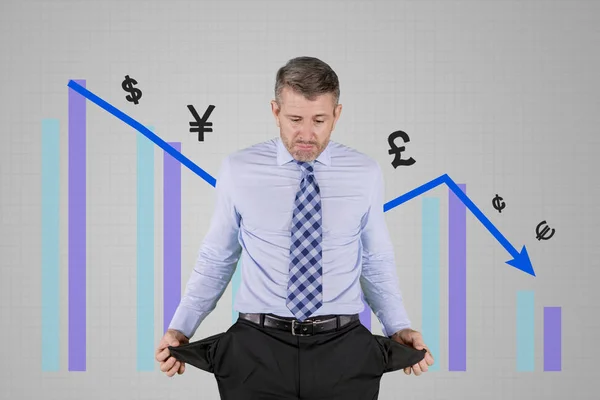 Stressed caucasian businessman showing empty pocket over decreasing business chart — Stock Photo, Image