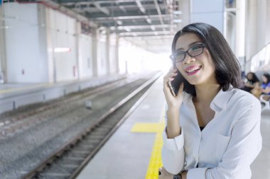 Güzel Asyalı iş kadını telefonda konuşuyor.