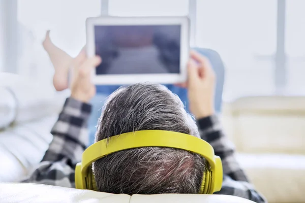 Hombre escuchando música mientras navega por Internet — Foto de Stock