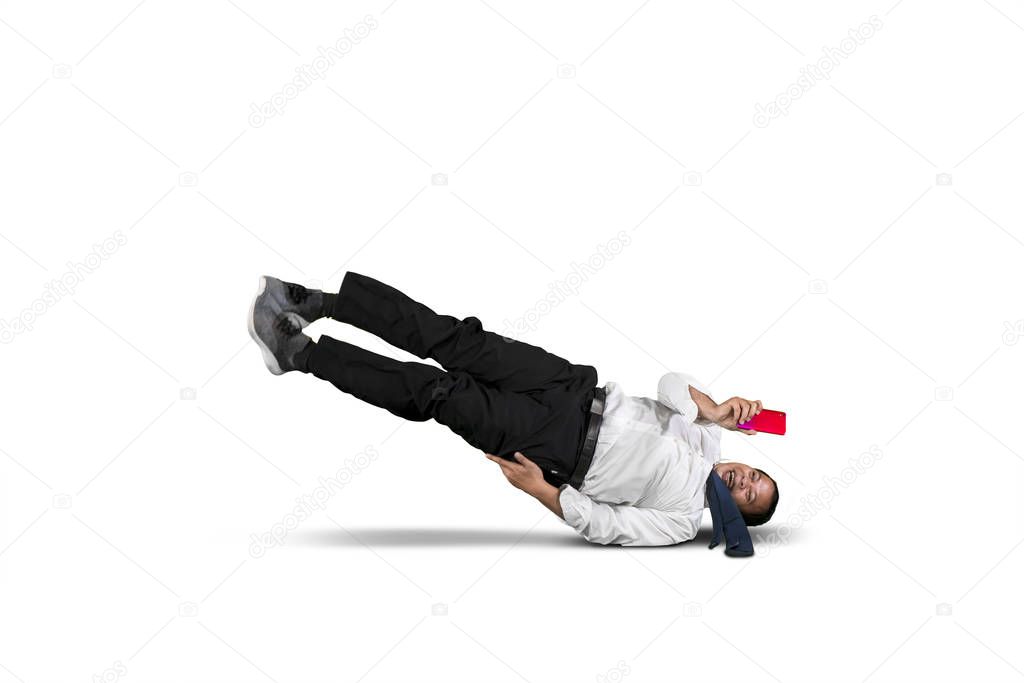 Businessman looking at his smart phone while falling