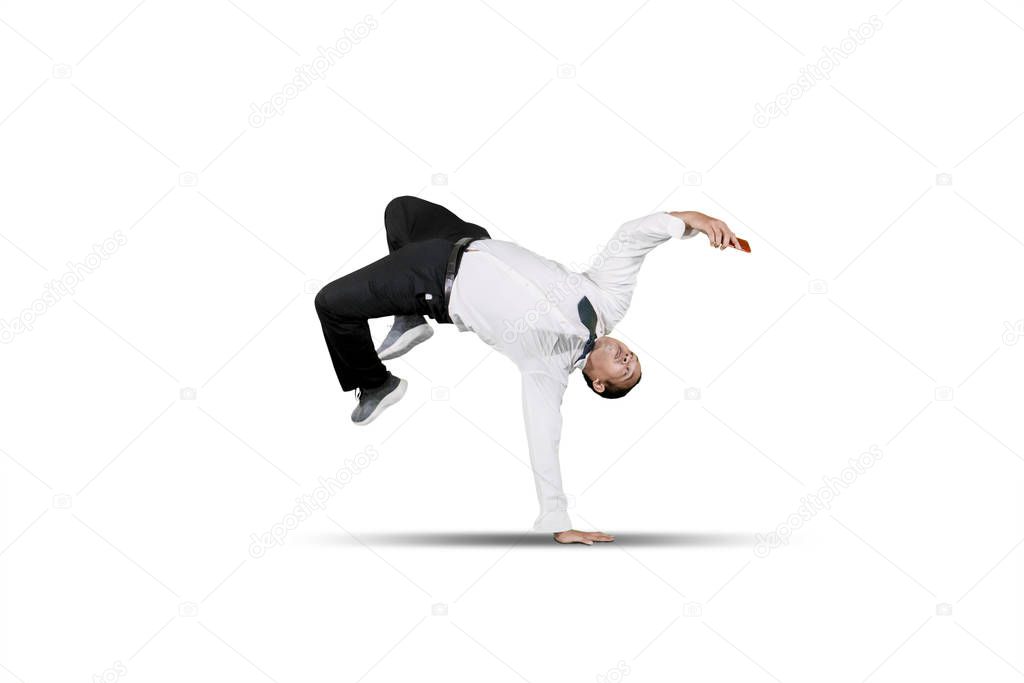 Businessman smiling looking at smart phone while doing some acrobatic moves