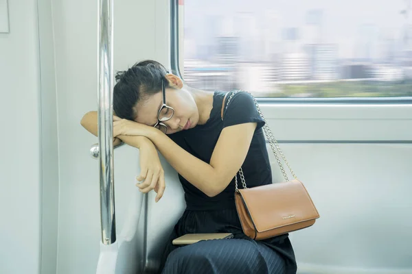 Passenger woman sitting and sleeping in a train