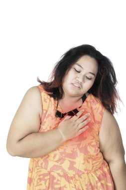 Şişko Asyalı kadın göğsünü acıyla ovuyor.