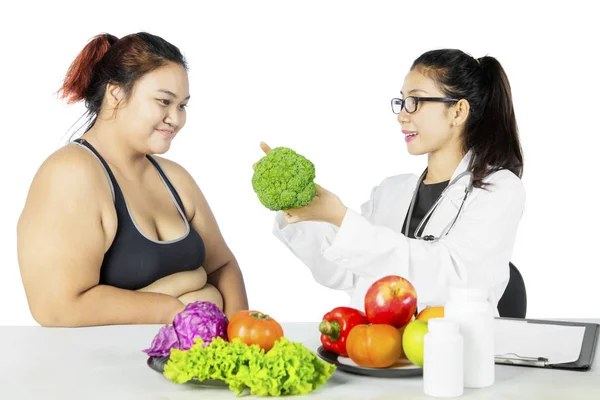 Médico sugerindo seu paciente gordo para comer vitaminas — Fotografia de Stock