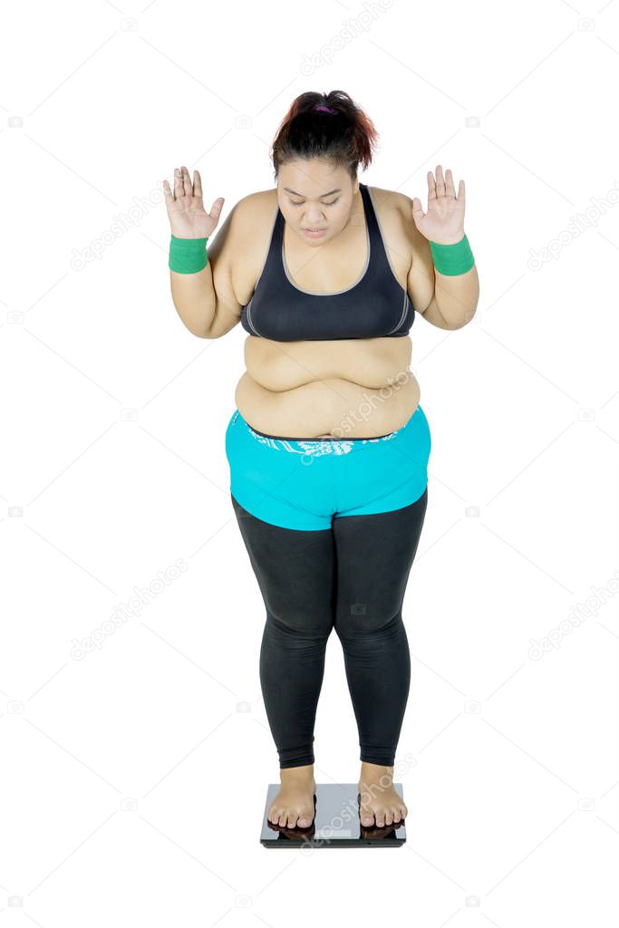 Fat Asian woman measuring her body weight