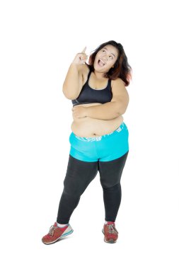 Şişko Asyalı kadın gülümsüyor ve parmağını kaldırıyor.