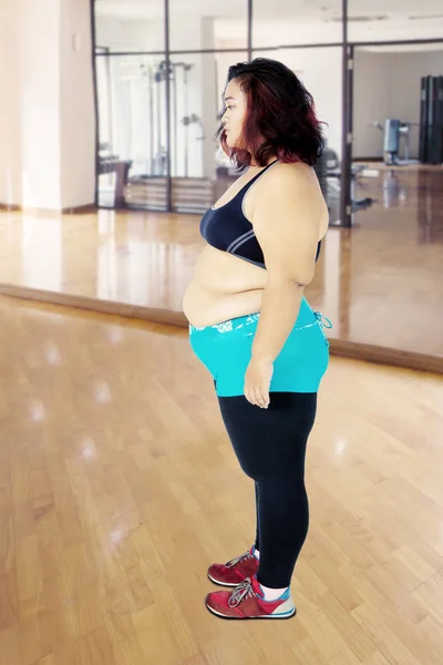 Mujer gorda mirando el espacio en blanco en el gimnasio — Foto de Stock