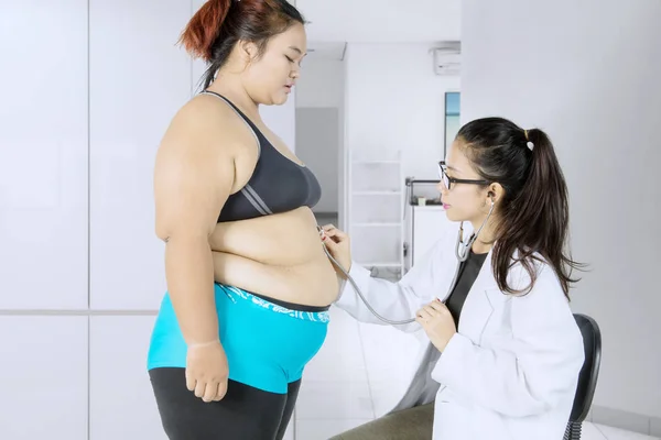 Mujer gorda visitando a su médico para hacerse un examen —  Fotos de Stock