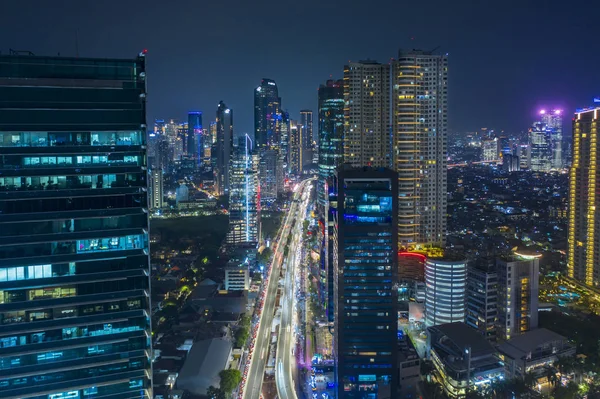 Aerial view of glowing buildings in hectic traffic — Stock Photo, Image