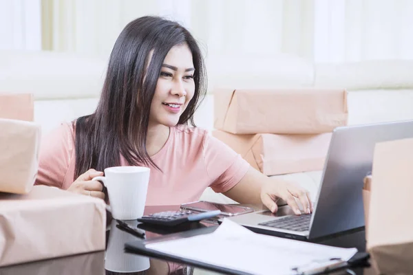 Asiatische Frau hält einen Drink während der Arbeit — Stockfoto