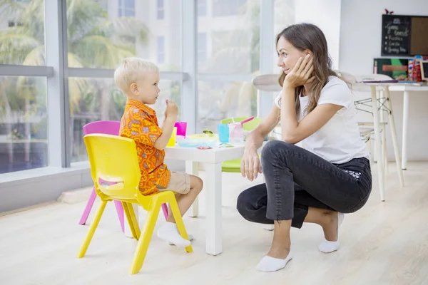 Junge starrt seine Lehrerin beim Essen unbeholfen an — Stockfoto