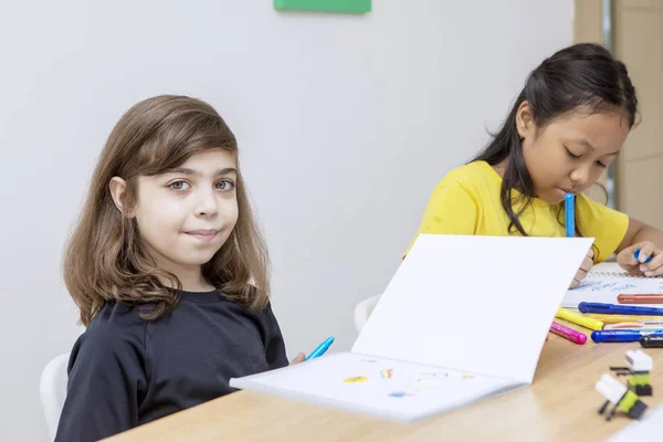 Blanc enfant souriant à la caméra tout en dessinant bleu — Photo