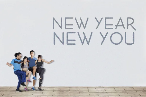 Four people celebrating New Year joyfully — Stock Photo, Image