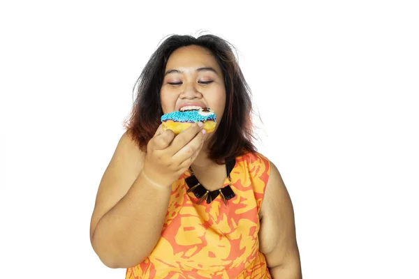 Portrét tlusté asijské ženy jíst koblihu — Stock fotografie