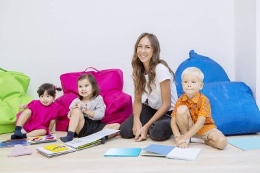 Öğretmen sevimli öğrencileriyle fotoğraf çekiyor.