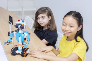 İki çocuk heyecanla lego robotlarını sunuyorlar.