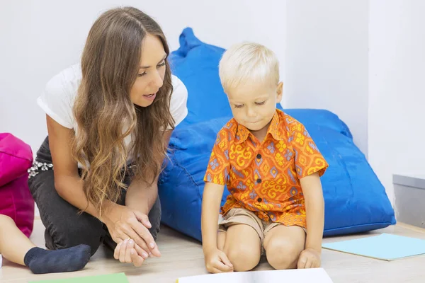 Lehrerin führt ihre Schülerin beim Betrachten einiger Zeichnungen — Stockfoto