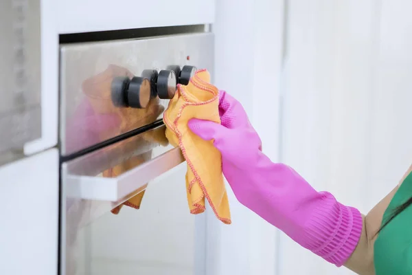 Fecho da mão direita esfregando e limpando um forno — Fotografia de Stock