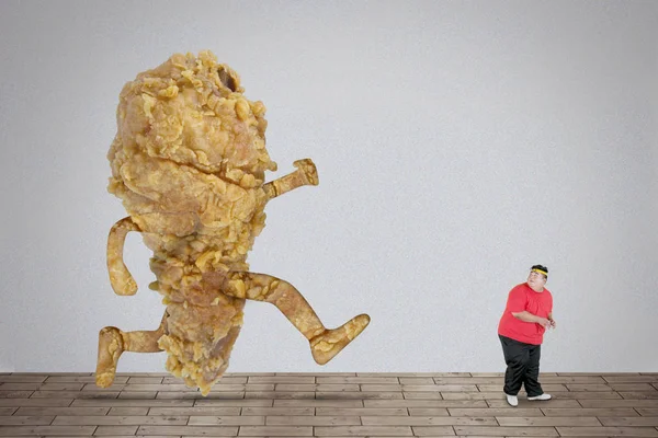 Fat Asian man being chased by fried chicken — Stock Photo, Image