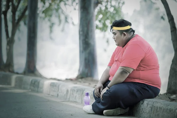 Gordo asiático homem descansando e cruzando suas pernas — Fotografia de Stock