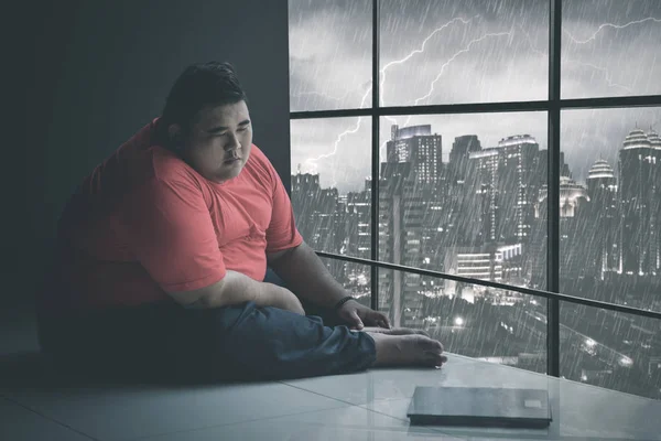 Gordo asiático homem olhando para suas escamas somberly — Fotografia de Stock