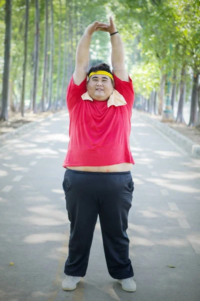 Tlustý asijský muž natahuje ruce na silnicích — Stock fotografie