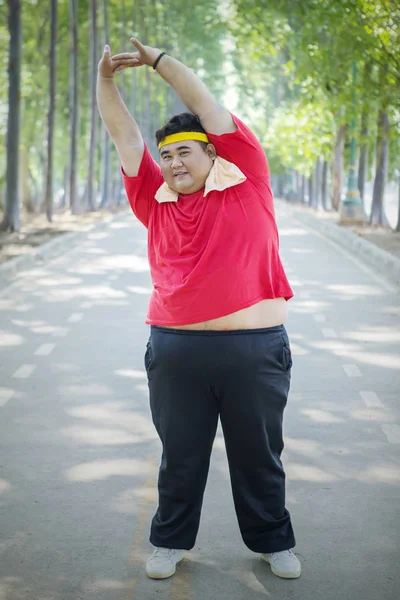 Fette asiatische Mann streckt seine Hände nach rechts — Stockfoto