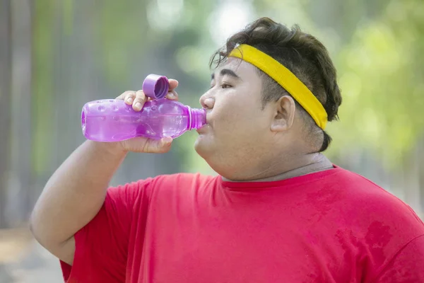 Retrato de gordura homem asiático bebendo água engarrafada — Fotografia de Stock