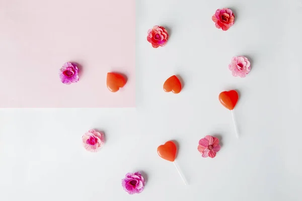 Top view of scrambled flower papers and lollipops — Stock Photo, Image