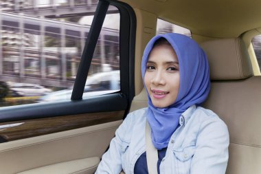 Arabasında kameraya gülümseyen güzel bir kadın.