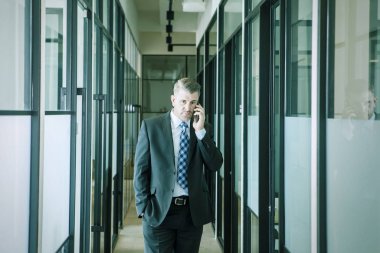 Ararken kameraya bakan yakışıklı iş adamı