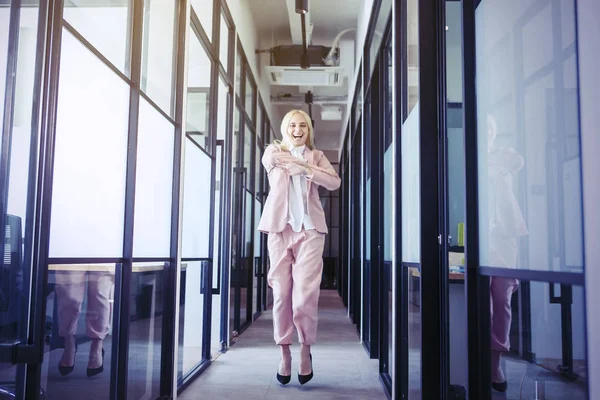 Blondynka bizneswoman skacze szczęśliwie i radośnie — Zdjęcie stockowe