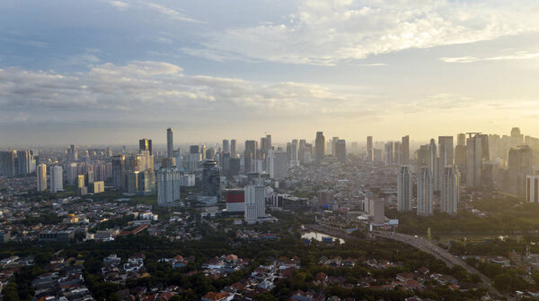 JAKARTA, Indonesia - December 18, 2019: Aerial view of Jakarta city full of skyscrapers radiated with bright sunlight