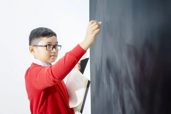 Vista laterale di un ragazzo asiatico che risolve un calcolo — Foto Stock