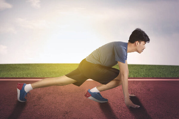 Вид сбоку на человека, кричащего и готовящегося к бегу
