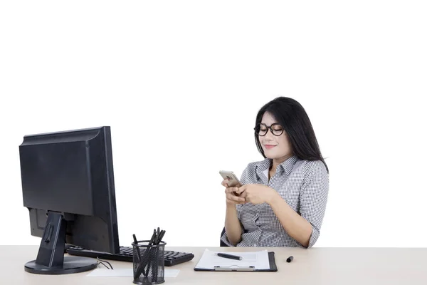 Mulher mensagens de texto alguém enquanto trabalhava em seu desktop — Fotografia de Stock