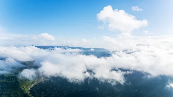 Luftaufnahme eines grünen Tals unter Kumuluswolken — Stockfoto