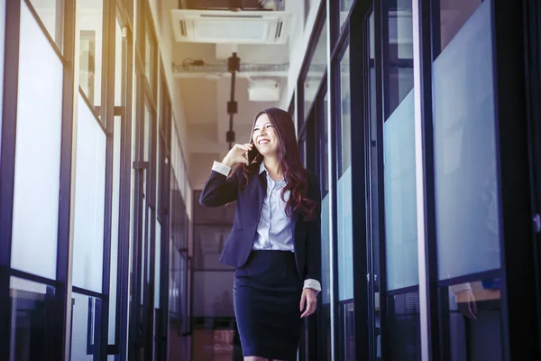 Asiatische Geschäftsfrau lächelt freudig, während sie anruft — Stockfoto