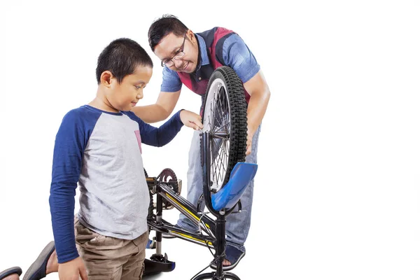 Азиат наставляет сына, как починить велосипед. — стоковое фото