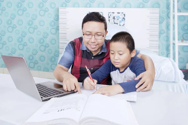Ένας Ασιάτης διδάσκει τον γιο του να διαβάζει. — Φωτογραφία Αρχείου