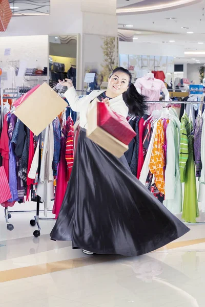 Asian woman dancing happily in a clothing store — Stock Photo, Image
