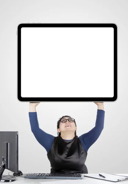 Beautiful businesswoman lifting a huge monitor — 스톡 사진